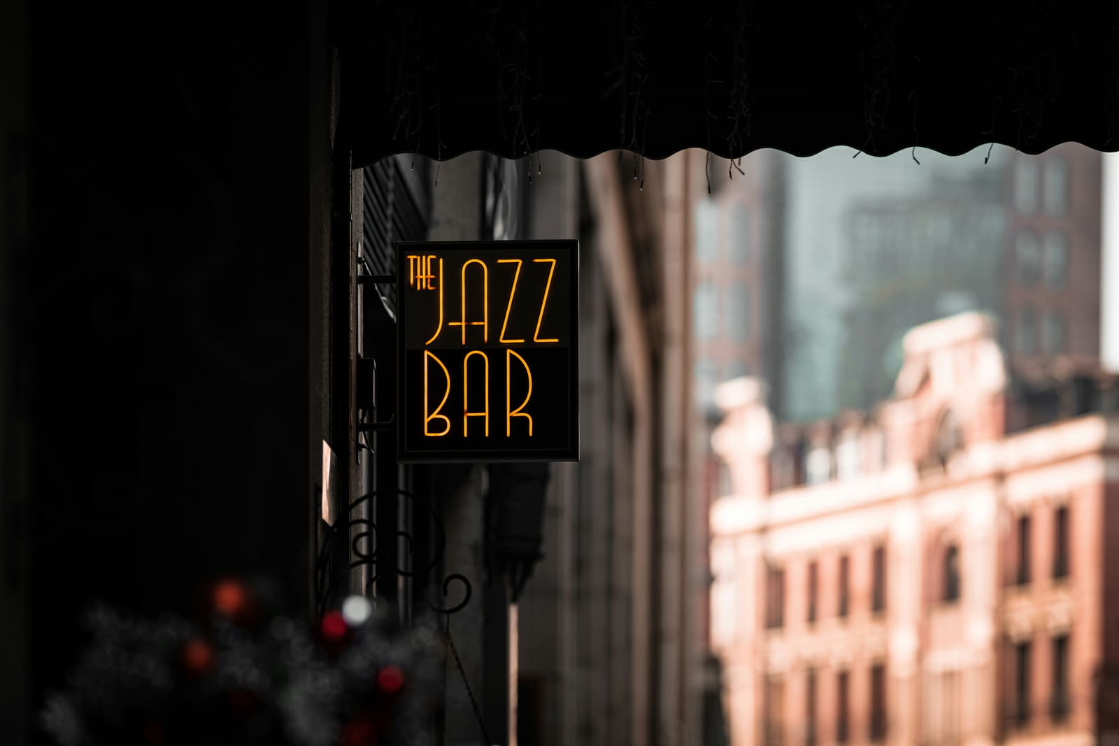 A glowing "Jazz Bar" neon sign above a night-lit doorway