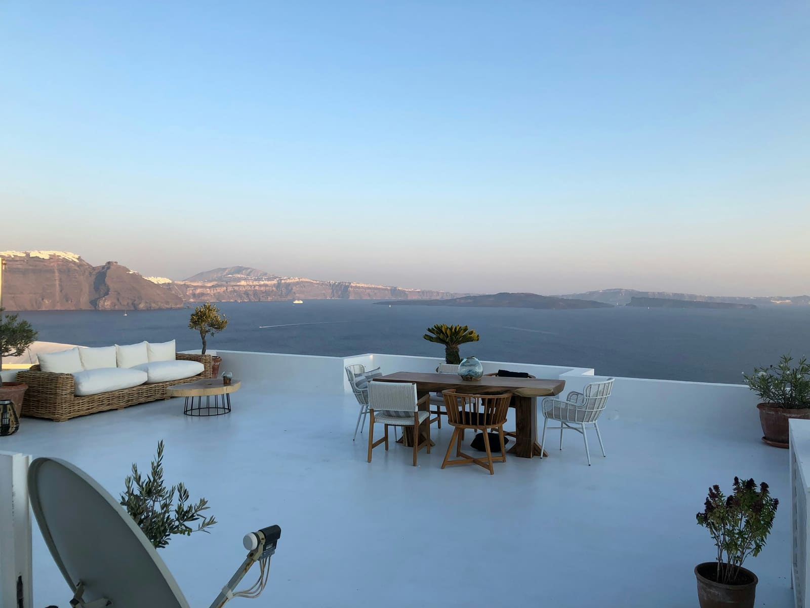 An empty terrace table overlooking the sea at dusk