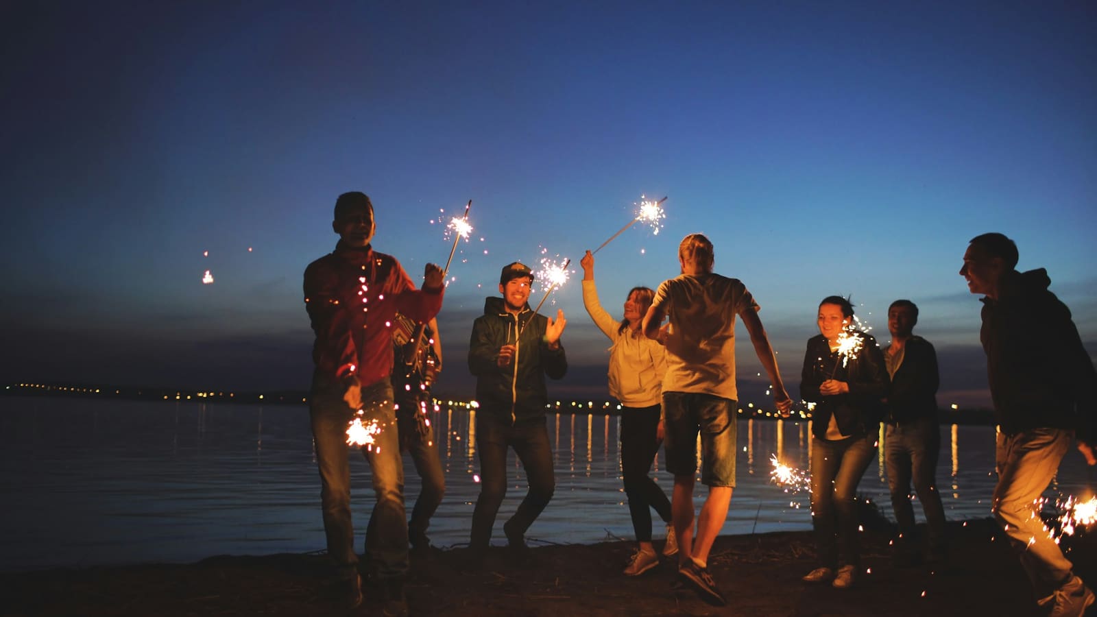 Friends celebrating together with sparklers at night